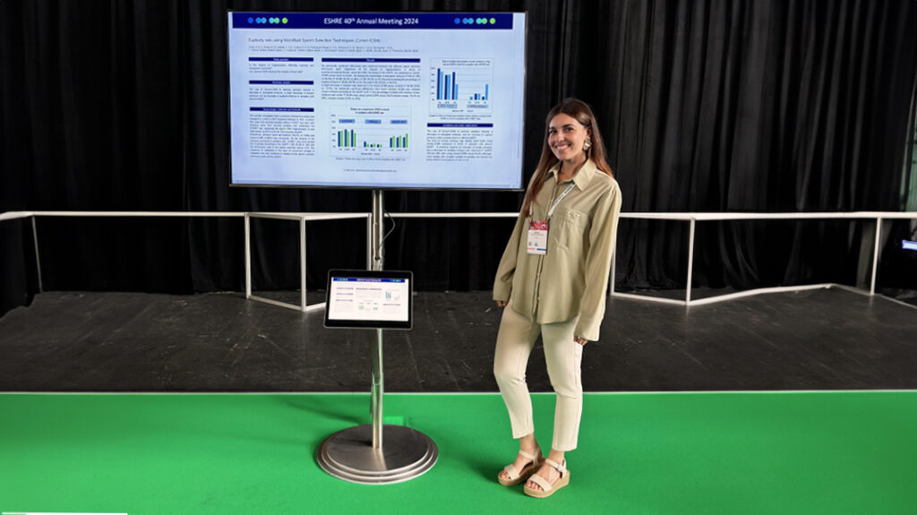 Embryologe Raquel García naast de poster van de ZyMot-ICSI studie.